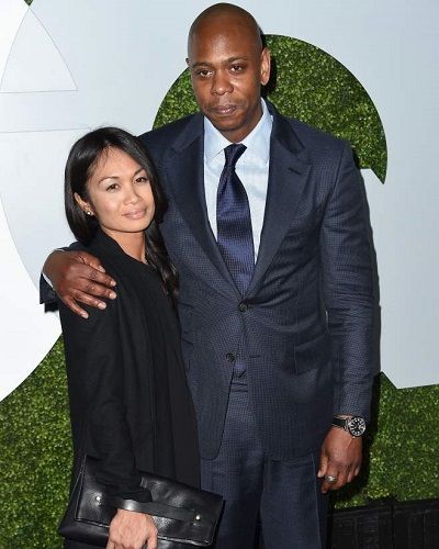 Dave Chapelle with his wife on a red carpet 