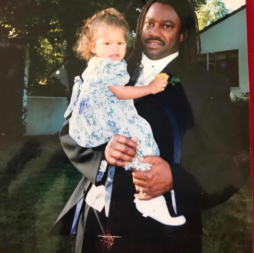 Zendaya as a child being carried by her father