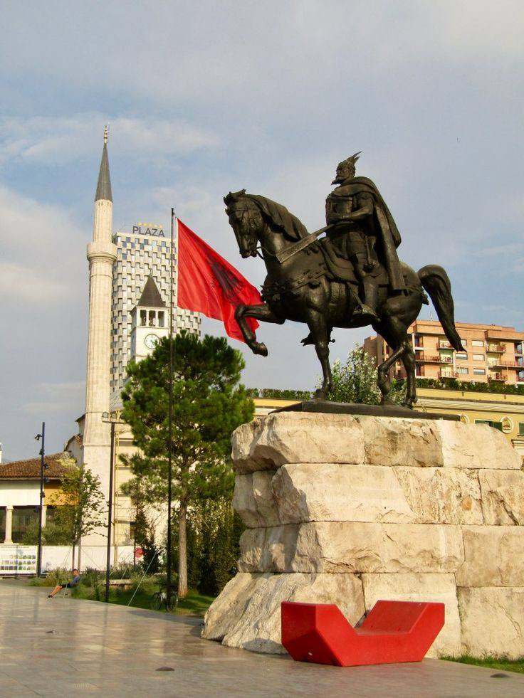 A picture of an Albanian flag and statue