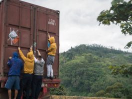 Migrants hanging on the back of a truck