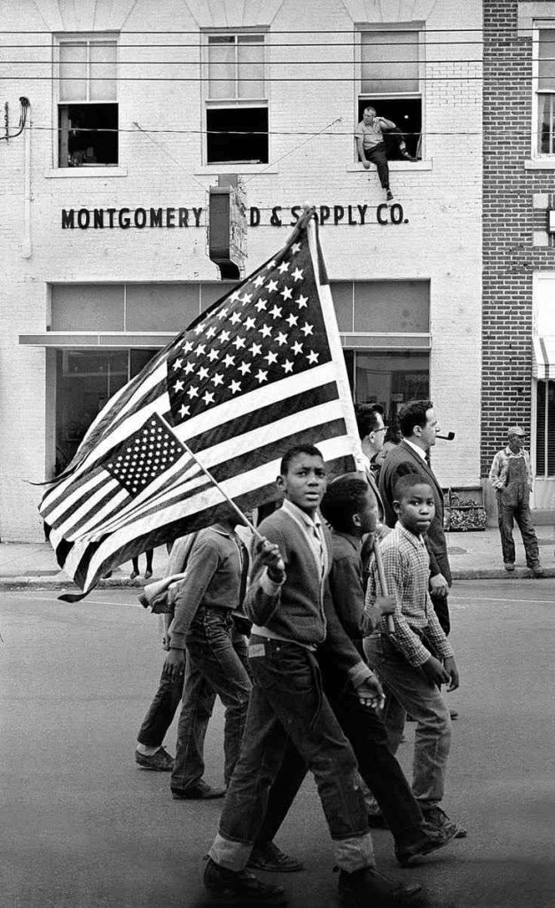 A picture of Black American children carrying the American flag