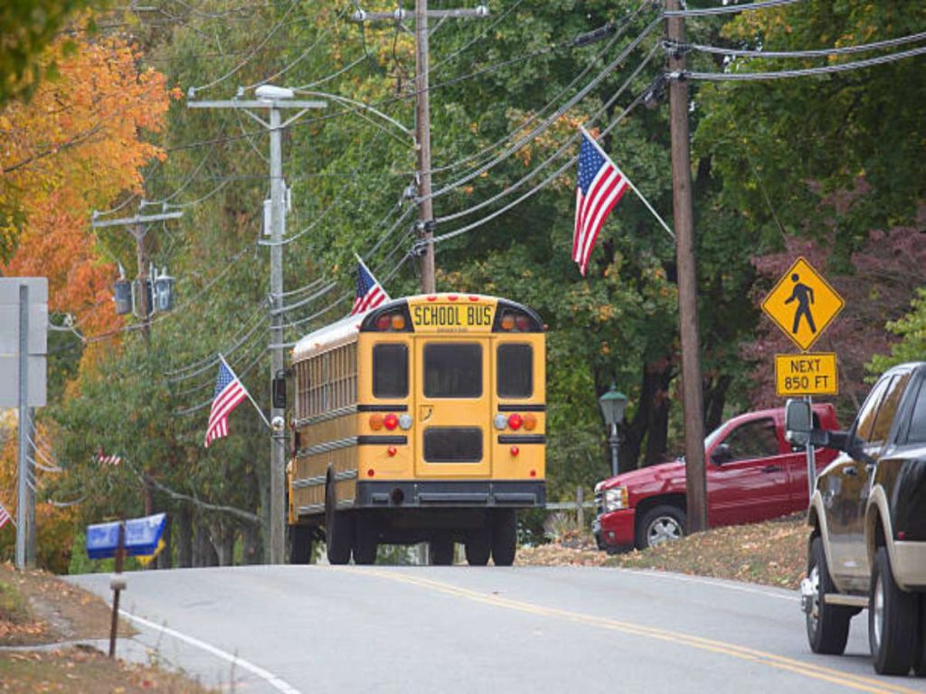 Small town school bus taking school children home in afternoon.

