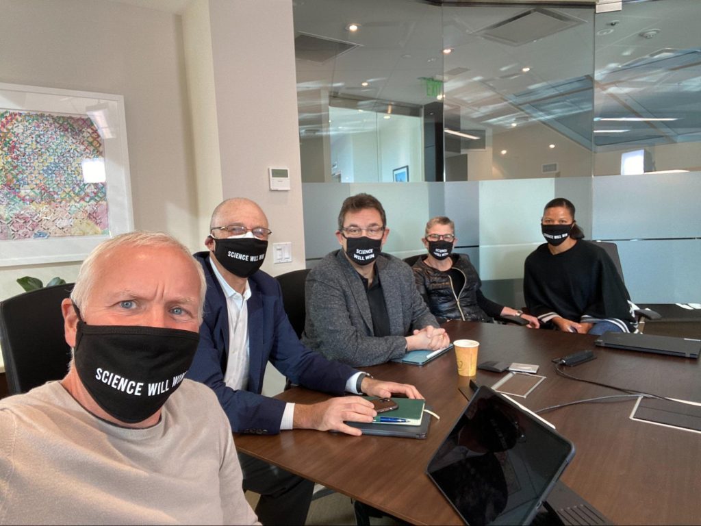 Pfizer CEO and others are wearing face masks in a boardroom
