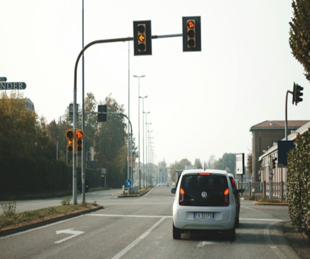 Two cars standing at a red light in Italy 