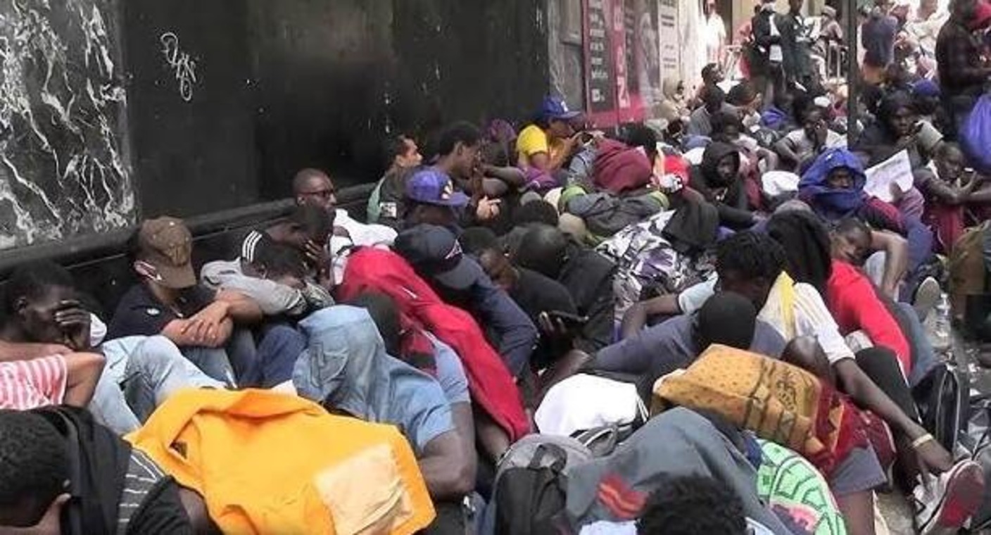Asylum seekers sitting out a queue