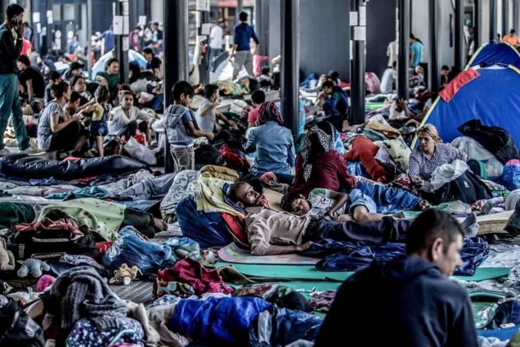 Migrants cluster around in a shelter