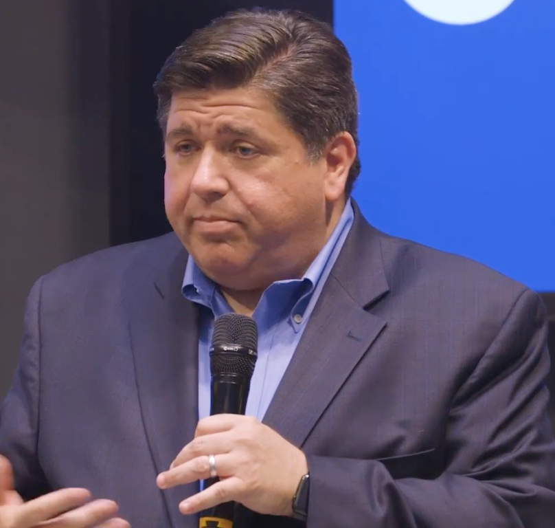 Pritzker holding a microphone