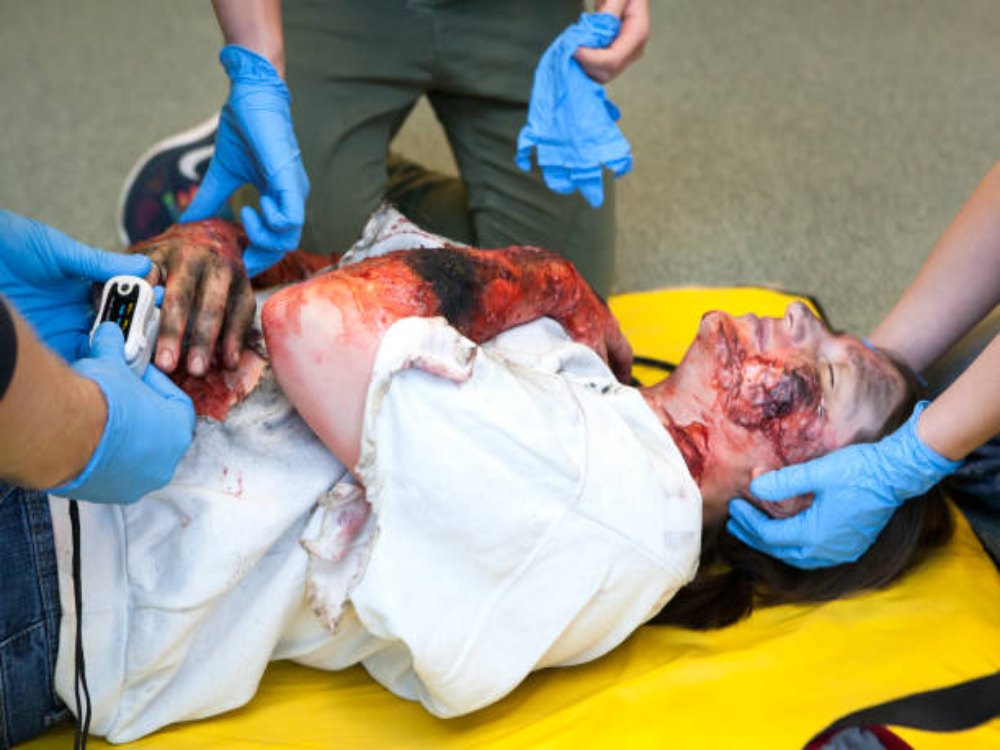 Paramedic professionals give injured first aid treatment.
