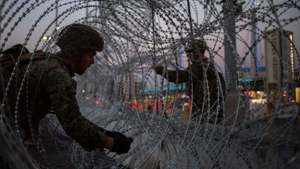 Soldiers installing a section of fence.