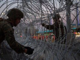 Soldiers installing a section of fence.