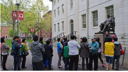 Students standing around the statue of John Harvard