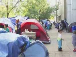 Kids playing around tents on a street curb