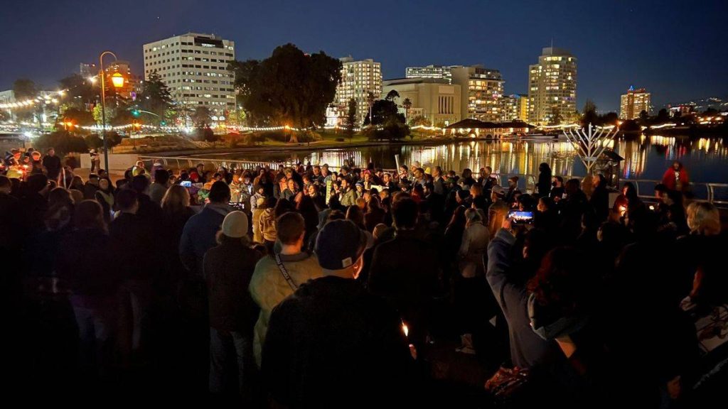 A large group at Lake Merritt by the large menorah