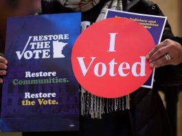 A demonstrator holding stickers in support of the Restore the Vote bill