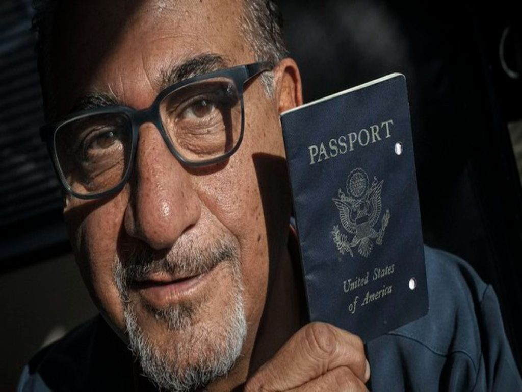 A pictured Siavash Sobhani, holding a black U.S. Passport