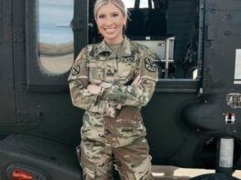 SSGT Michelle Young in front of a military helicopter.