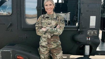 SSGT Michelle Young in front of a military helicopter.