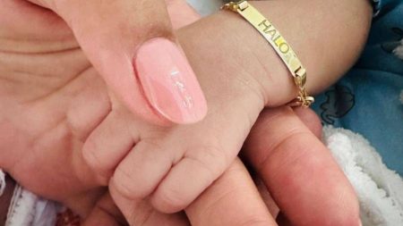 Baby Halo wearing a gold bracelet with his name engraved on it.