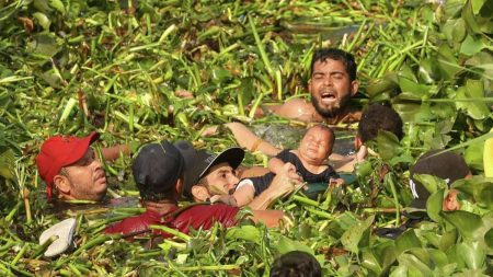 A group of migrants trying to swim across the Rio Grande River with a baby