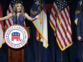 Donald standing by as Lara Trump addresses the audience