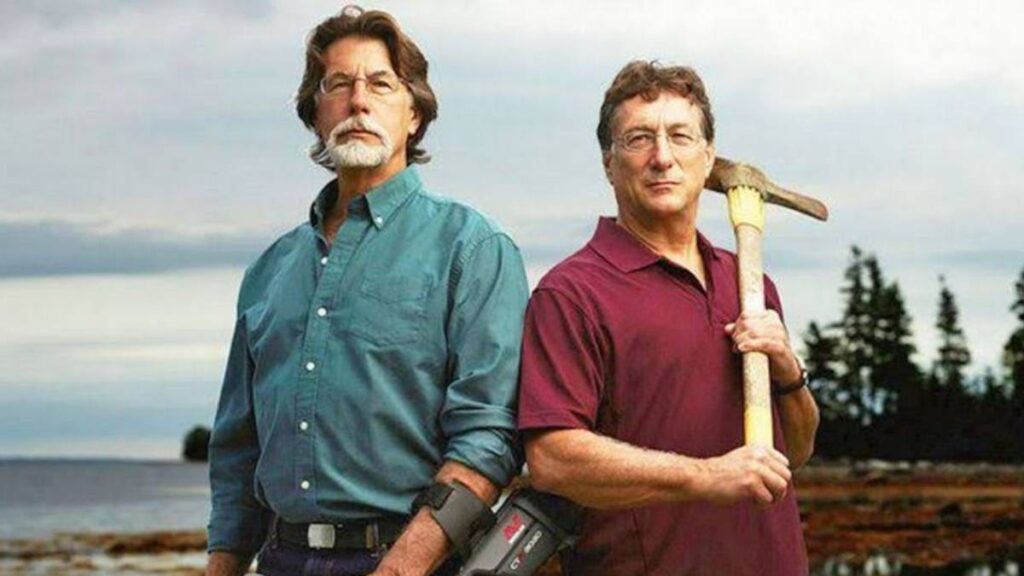 Marty holding a metal detector and Rick an axe