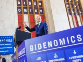 President Biden delivers remarks in Chicago surrounded by signage that reads: “Bidenomics.”
