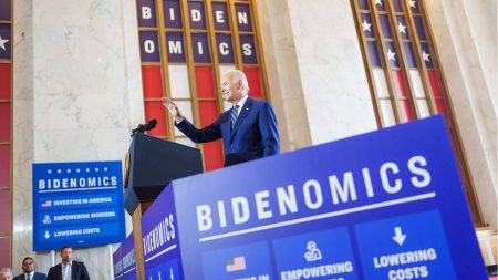 President Biden delivers remarks in Chicago surrounded by signage that reads: “Bidenomics.”