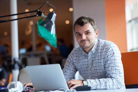 A man with a laptop in an office