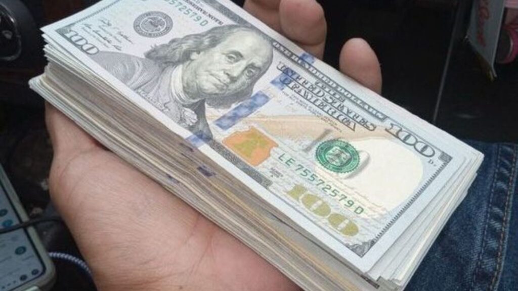 A stack of $100 bills in someone’s palm