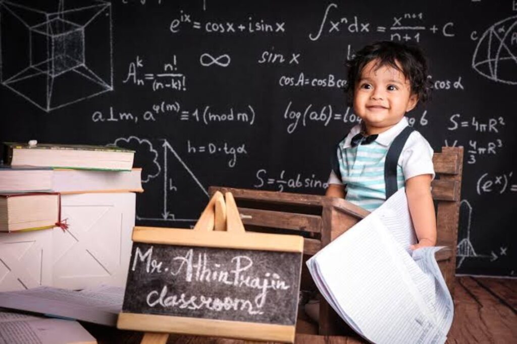 A female toddler smiling in front of a chalkboard
