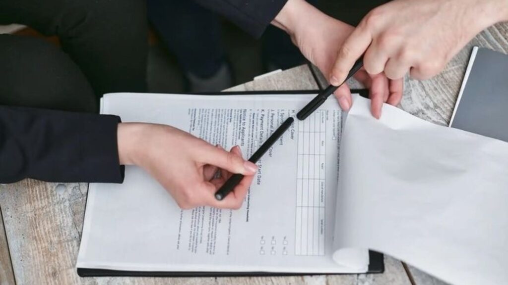 Two hands pointing at a document.