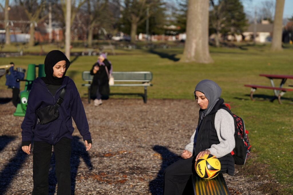 Two Muslim women at a park, both wearing hijabs