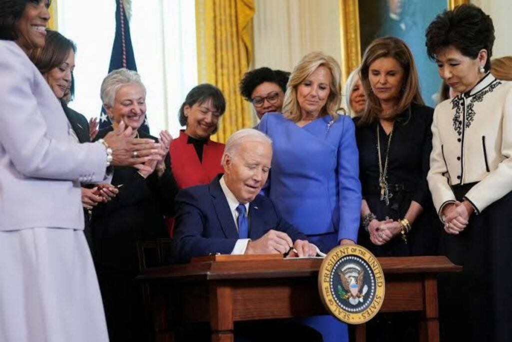 A picture of President Joe Biden signing the executive order