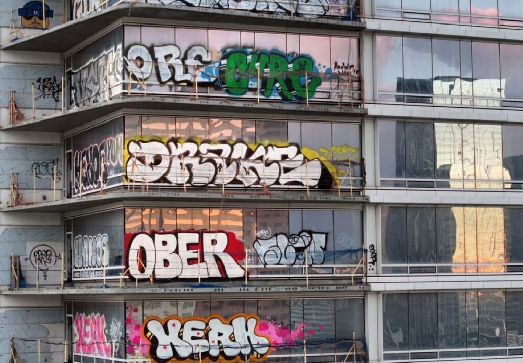 A photo of a high rise building covered with graffitti