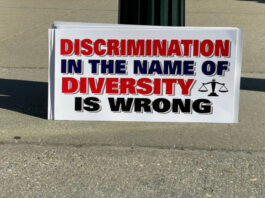 A Photo of a Placard that says "Discrimination in the name of Diversity is Wrong"
