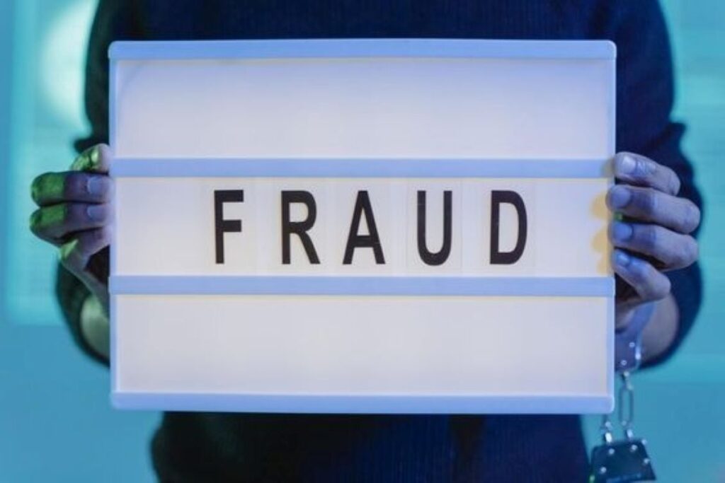 A person holding something with fraud written on it