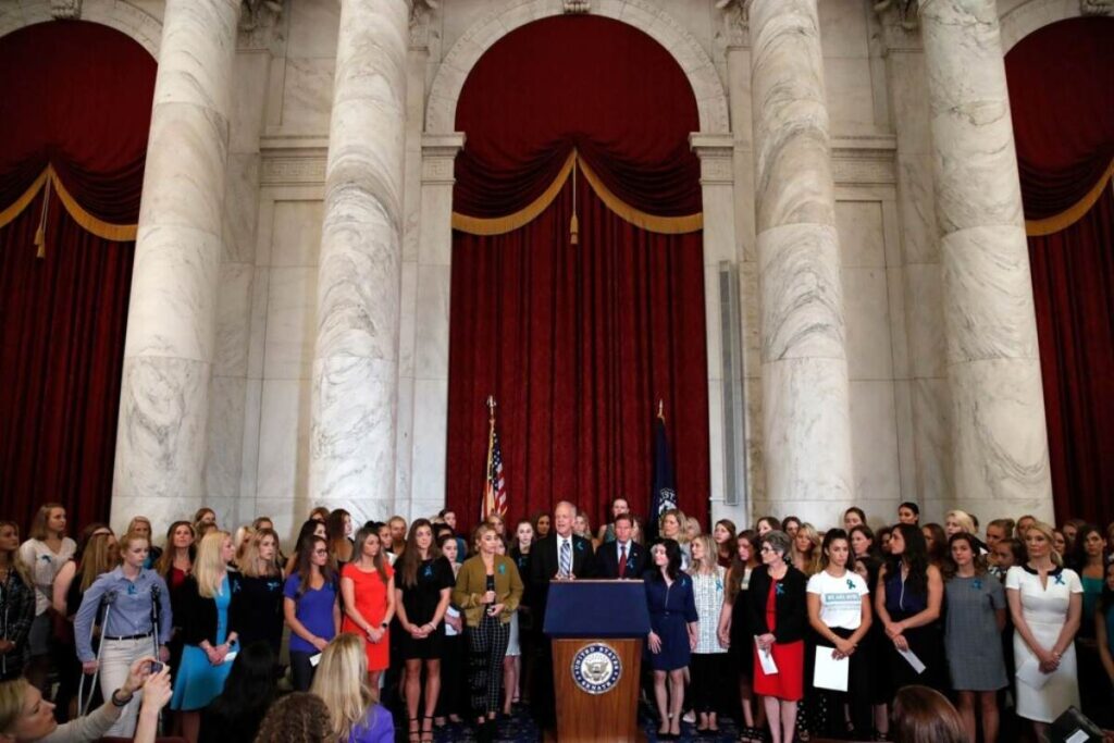 A picture of Sen. Jerry Moran with women abused by Larry Nassar.