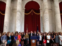 A picture of Sen. Jerry Moran with women abused by Larry Nassar.