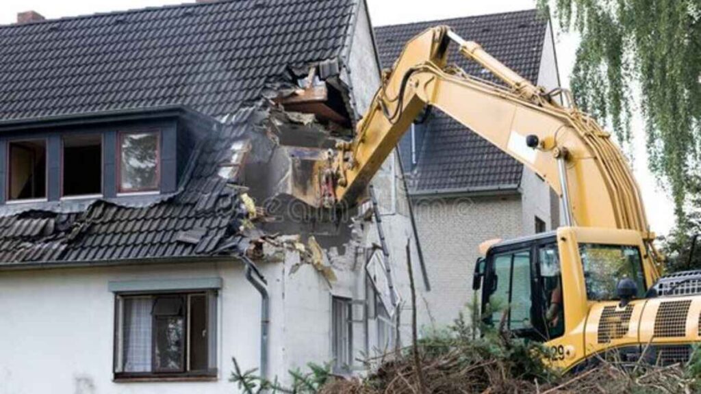 A tractor demolishing a home