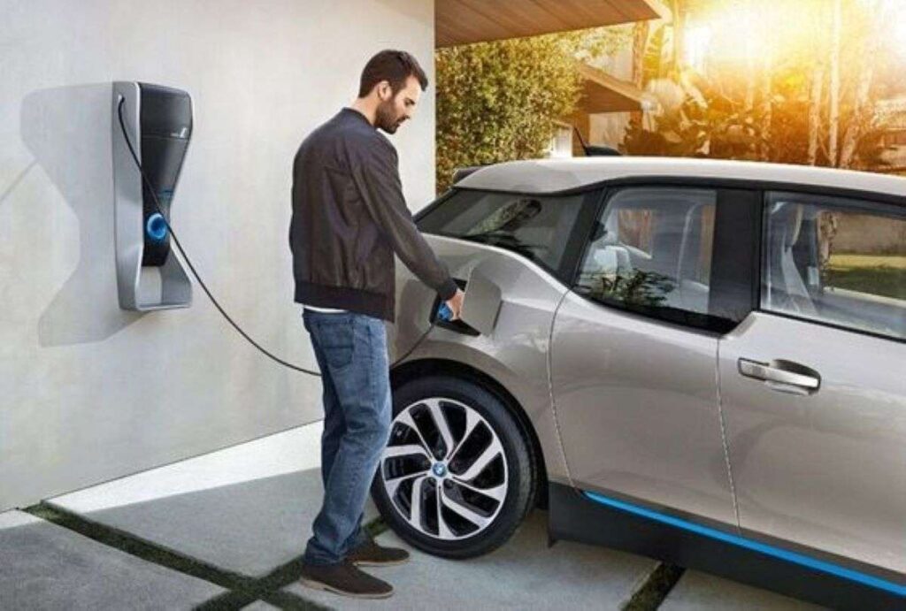 A man charging an EV at home