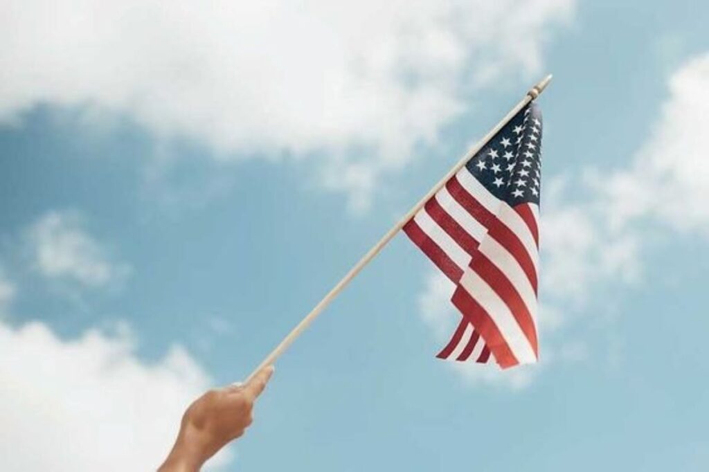 A person holding a mini United States flag