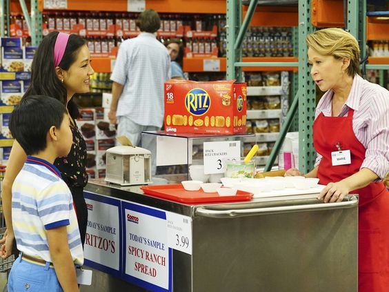 A mother and child interacting with a Costco worker