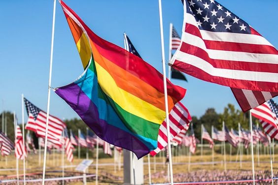 The queer flag standing next to the US flag 