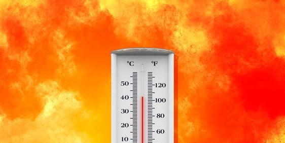 A thermometer showing high temperature set against a fiery backdrop