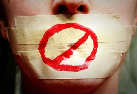 A person with their mouth sealed with paper tape with a censorship sign drawn on it