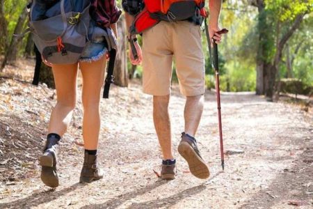 Two hikers with gear on a hiking trail