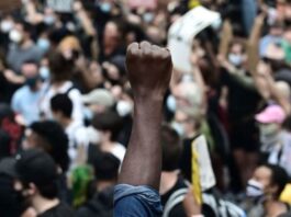 A man in a crowd holding up a fist