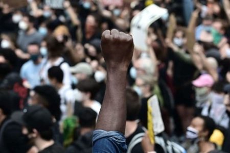 A man in a crowd holding up a fist