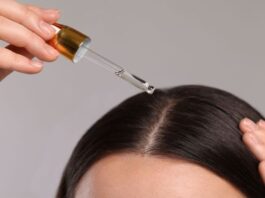 A picture of a woman applying hair growth oil