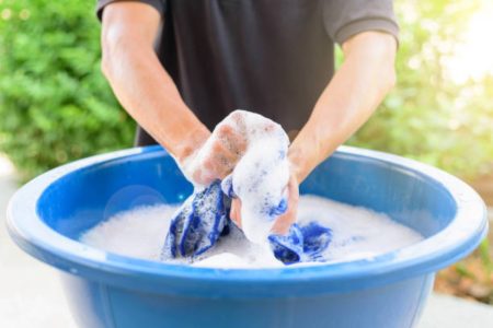 A picture of a person washing clothes by hand